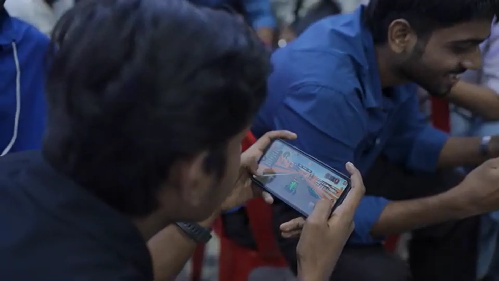 Student intensely playing mobile game during Infinite Pro League esports tournament